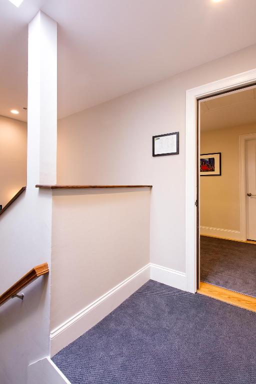 an empty room with a door leading to a hallway at West Broadway Quarters by Thatch in Boston