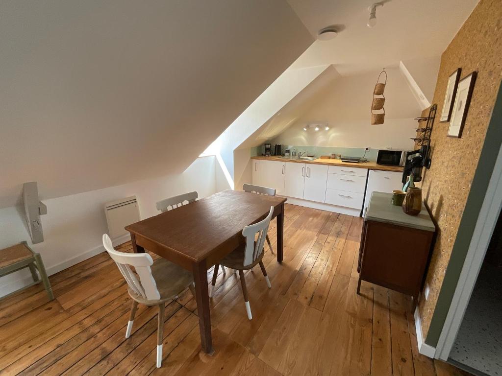 una cucina e una sala da pranzo con tavolo e sedie in legno di Sous les toits de la Tavarn Ty Gar a Hennebont