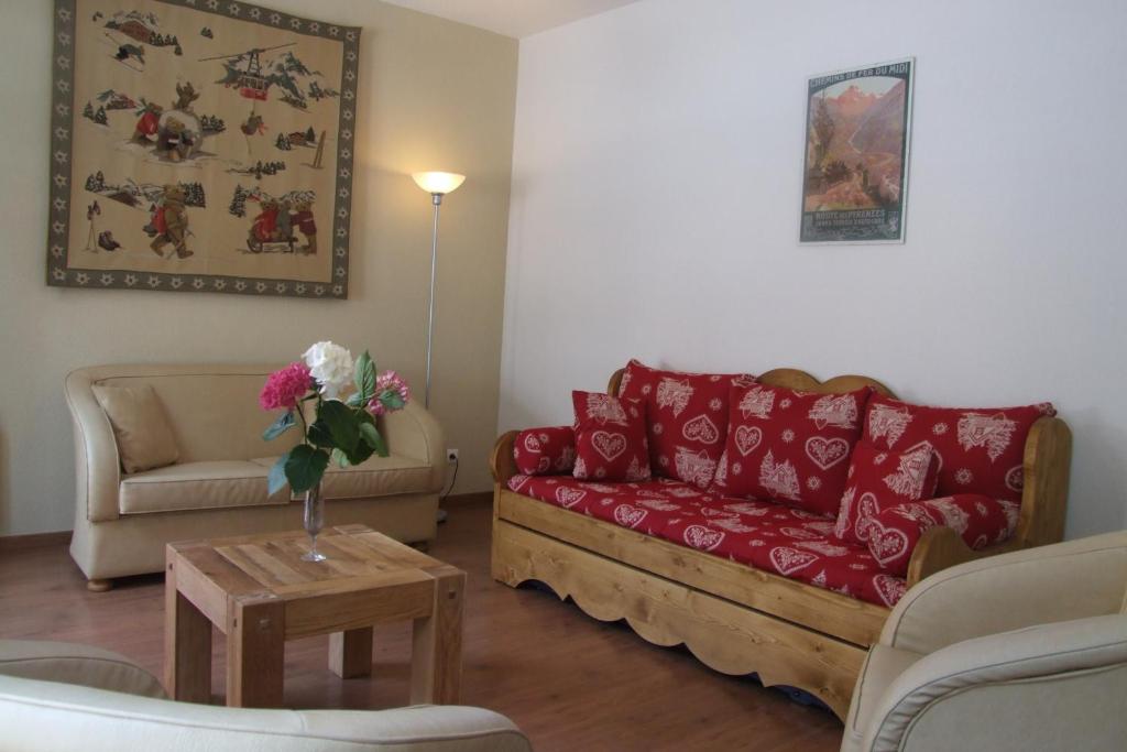 - un salon avec un canapé rouge et une table dans l'établissement Vacances Perennes, à Cauterets