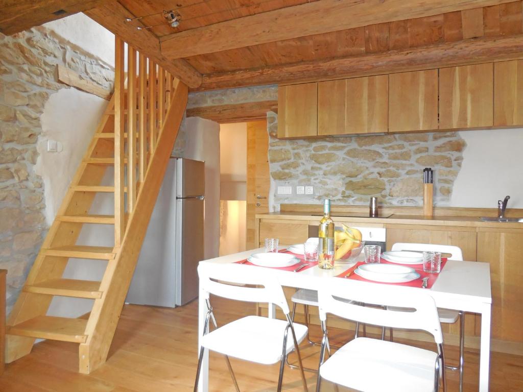 a kitchen with a white table and white chairs at Stone House Apartments in Brtonigla