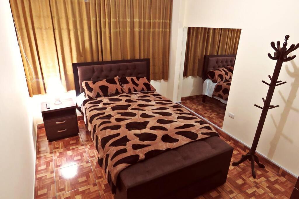 une chambre avec un grand lit avec une couverture à imprimé léopard dans l'établissement Depawanka 3 Departamento amoblado y equipada, à Huancayo