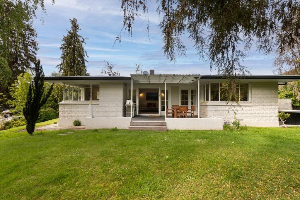 a white house with a lawn in front of it at Central Arrowtown - 4 Beds and Hot Tub! in Arrowtown
