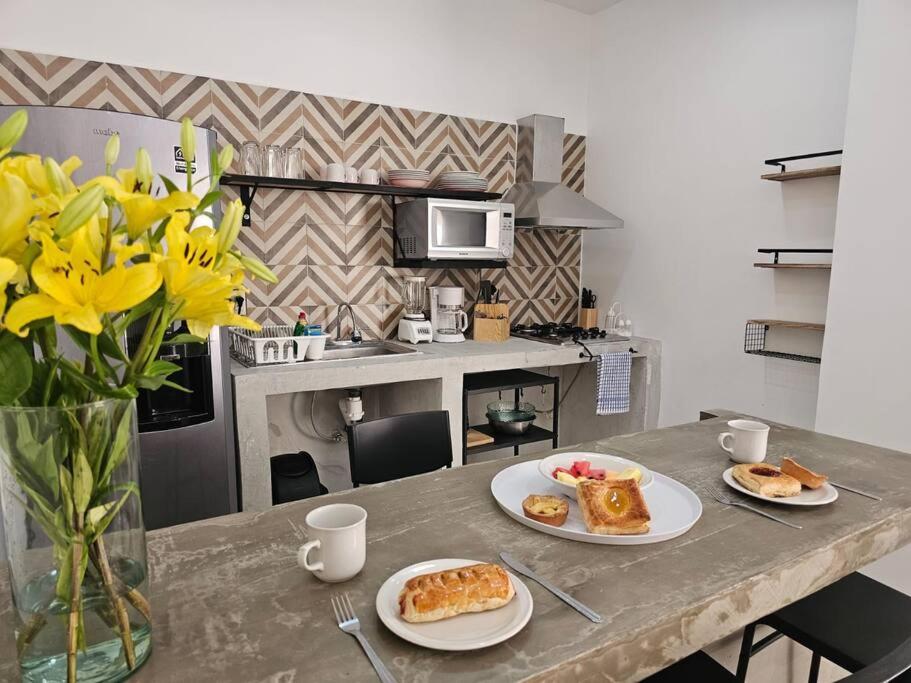 einen Tisch mit zwei Teller Essen und einer Vase Blumen in der Unterkunft Hermoso Apartamento 2 recámaras L4 in Puerto Vallarta