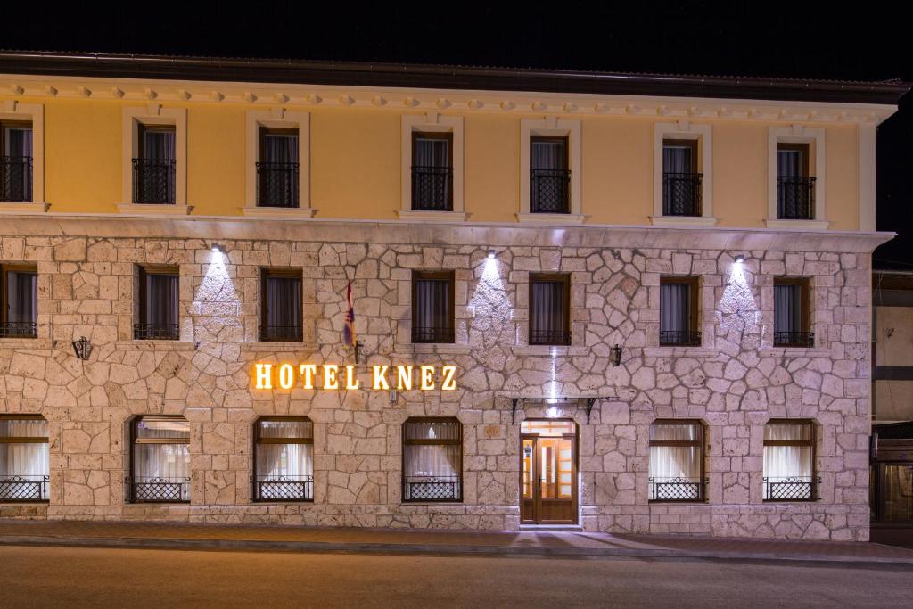 un bâtiment avec un panneau d'hôtel dans l'établissement Hotel Knez, à Kupres