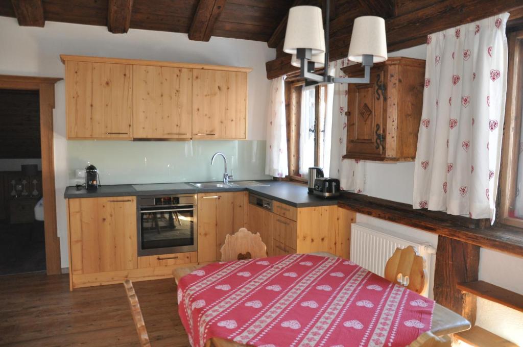 eine Küche mit Holzschränken und einem Tisch darin in der Unterkunft Appartement Elisabeth in Kitzbühel