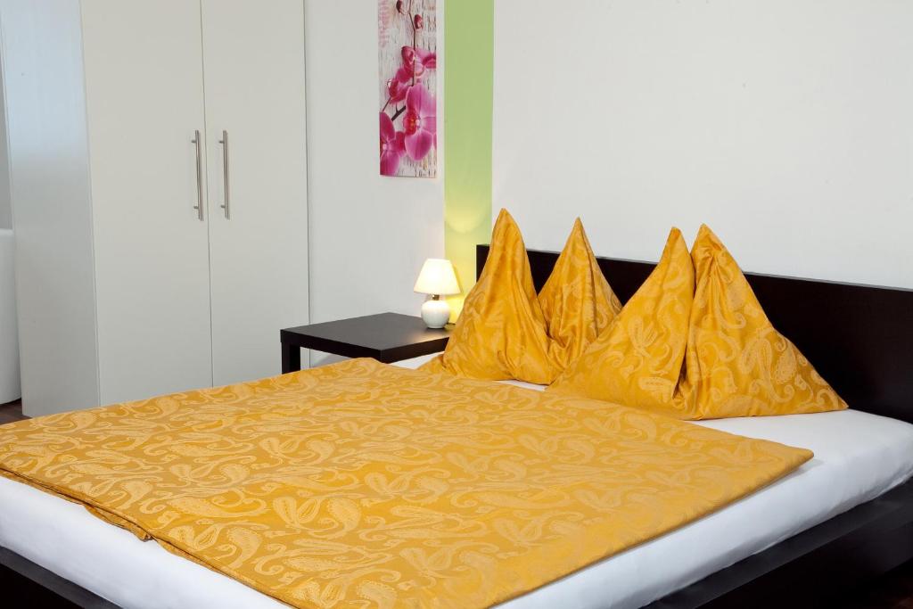 a bedroom with a bed with yellow pillows at Erlachmühle in Mondsee