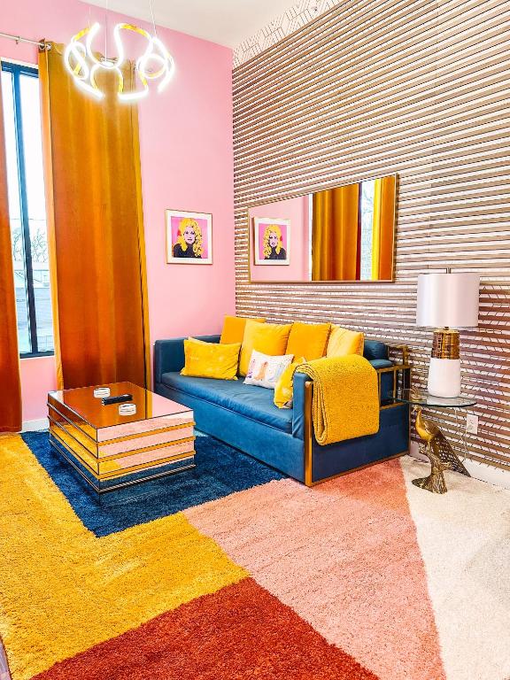 Hotel Dolly's Art Deco - Luxe Stay Near Broadway, a living room with a blue couch and yellow pillows at Dolly's Art Deco - Luxe Stay Near Broadway in Nashville