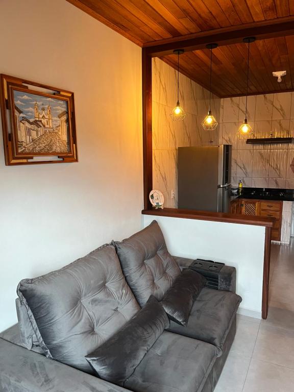 a leather couch in a living room with a kitchen at Casa Almeida in Tiradentes