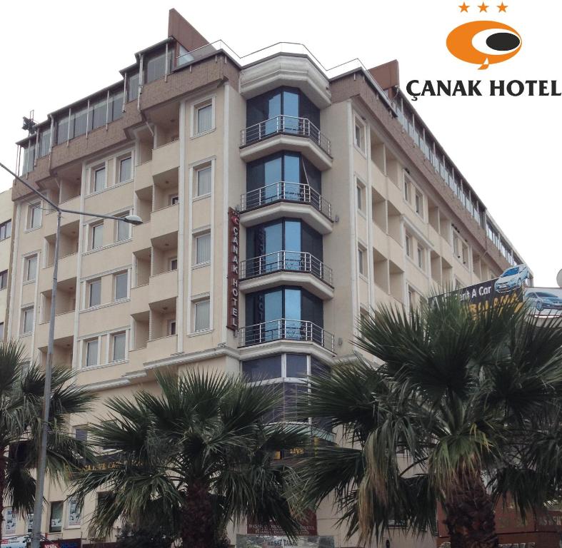 ein großes Gebäude mit Palmen davor in der Unterkunft Çanak Hotel in Canakkale