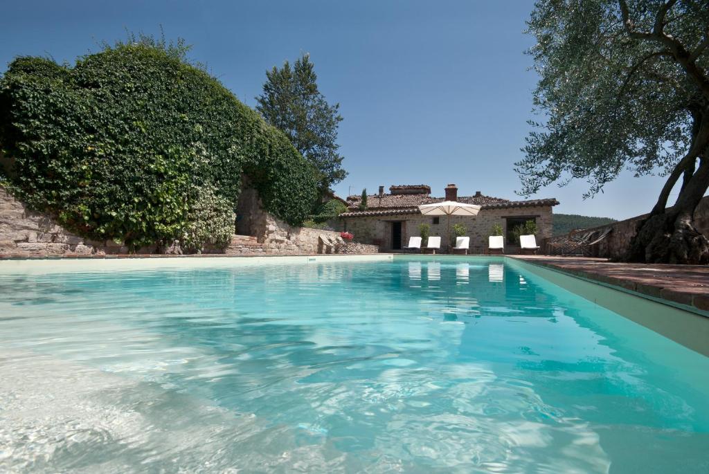 a pool with blue water in front of a house at Fattoria L' Aquilone in Poggio Aquilone