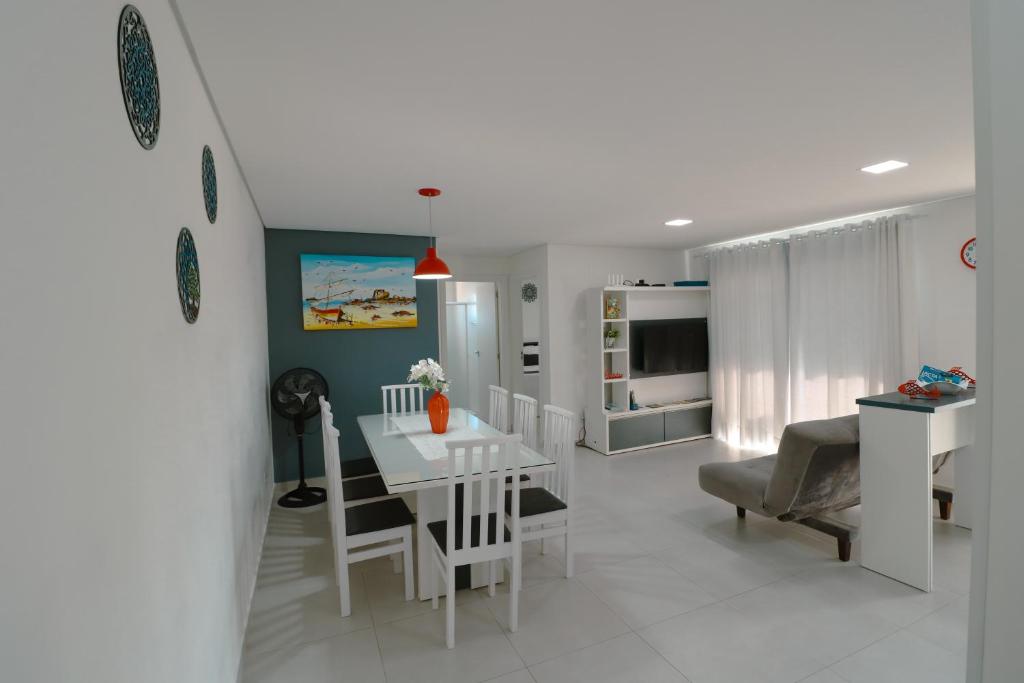 a kitchen and living room with a white table and chairs at Apartamento Familiar II - Vista para o mar e próximo ao Beto Carrero in Penha