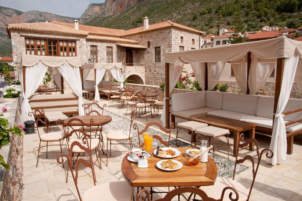 a patio with tables and chairs and a building at Archontiko Hatzipanayioti in Leonidio