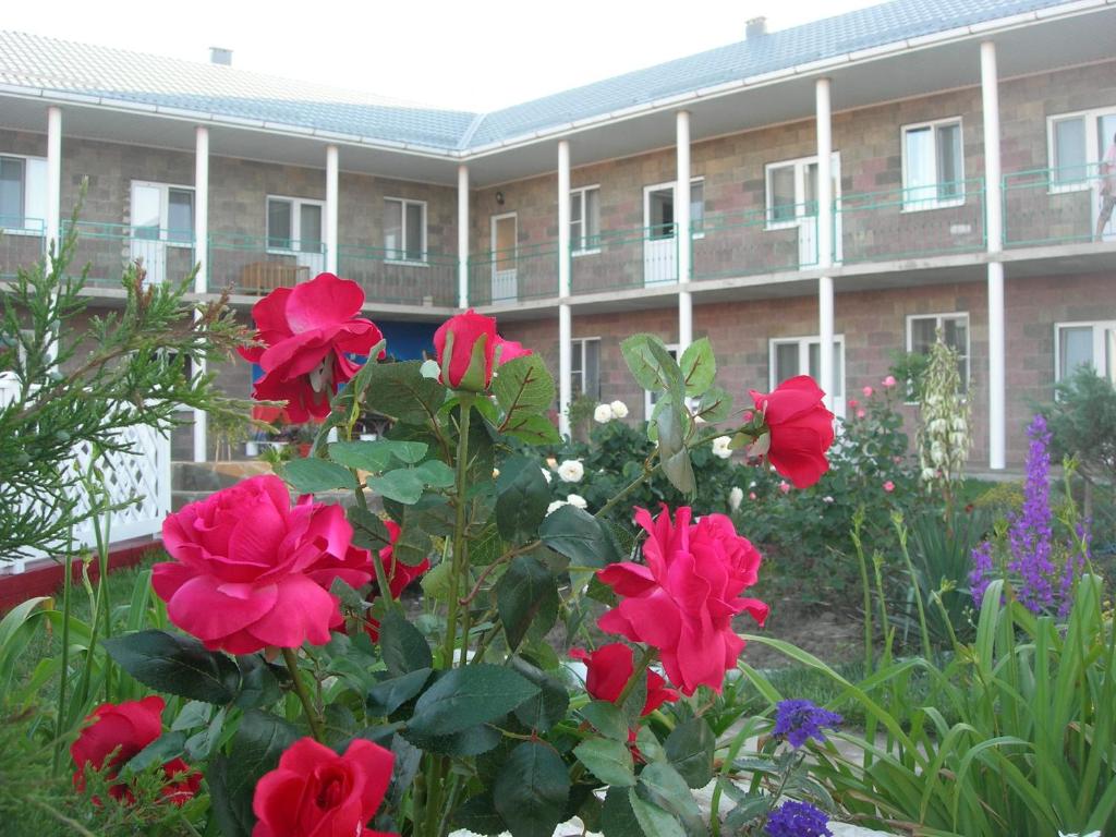 a garden with red roses in front of a building at Sankt-Peterburg in Peresyp