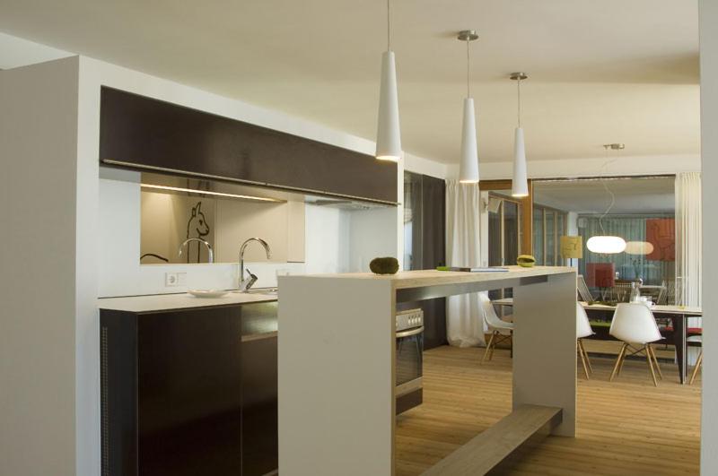 a kitchen with a counter and a living room at LAMA Appartement in Lech am Arlberg