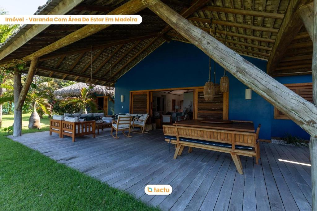 a porch with a wooden deck with a house at Villa Boungavilea Fortim Casa Frente Mar de Luxo in Fortim