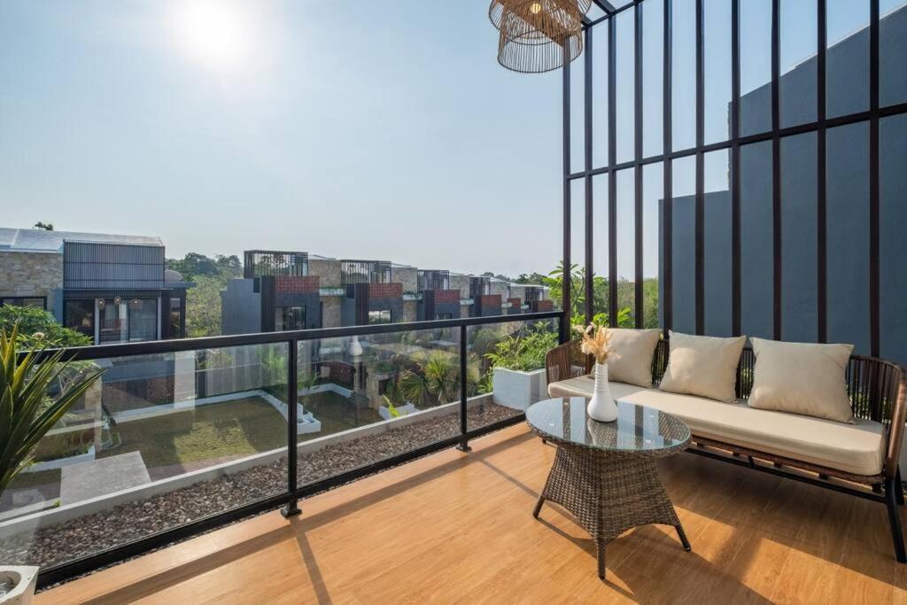 ein Balkon mit einer Couch und einem Tisch auf einem Gebäude in der Unterkunft Private Villa Ayra 9A 10mins to Melasti Beach in Uluwatu