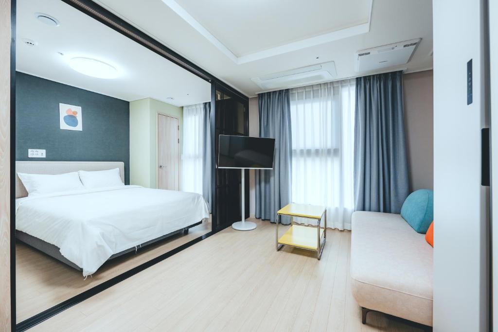 Postel nebo postele na pokoji v ubytování H Avenue Sasang Station Residence Hotel