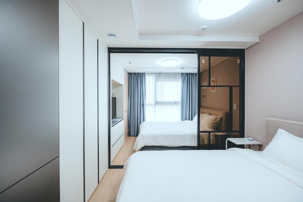 Postel nebo postele na pokoji v ubytování H Avenue Sasang Station Residence Hotel