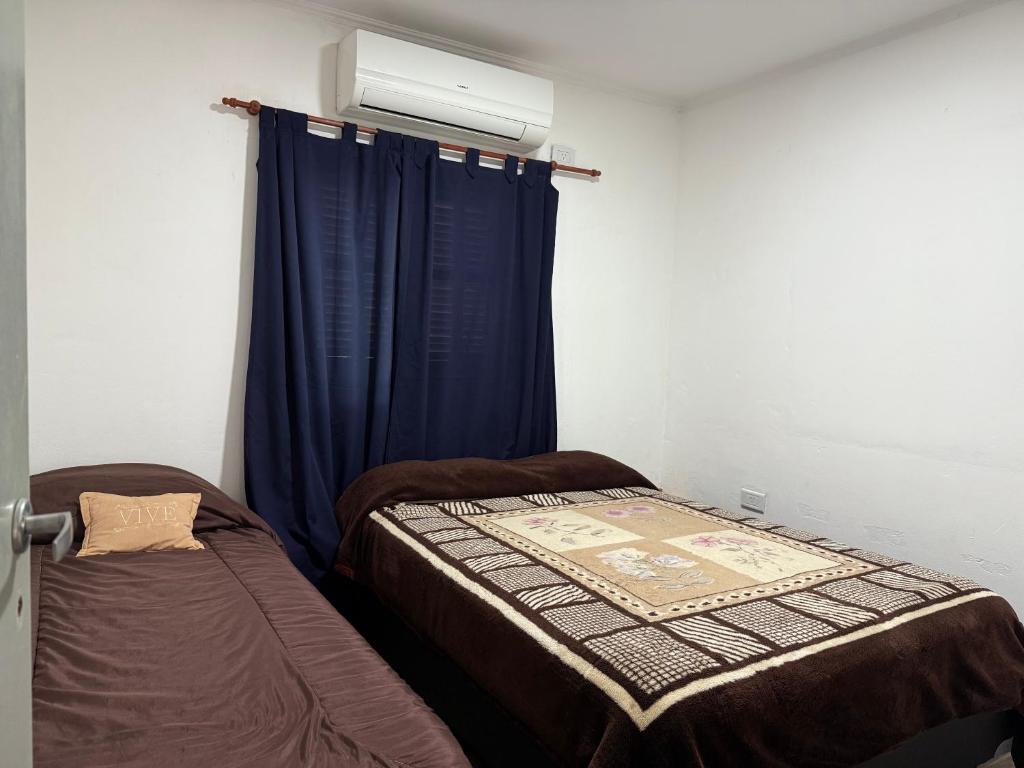 a bedroom with two beds and a blue curtain at Tu lugar de Descanso II in Federación
