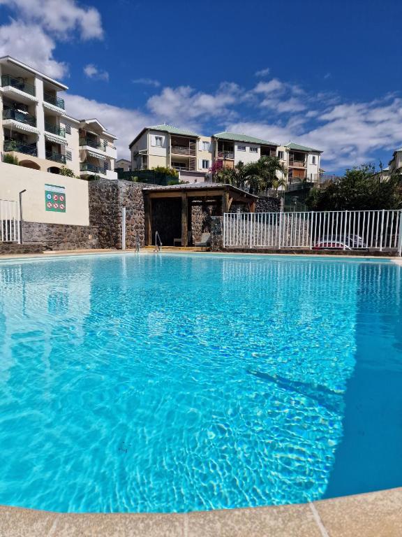 サンジルレバンにあるAppartement Villa sur le toit, vue merの一部のアパートメントの前に青い大型スイミングプールがあります。