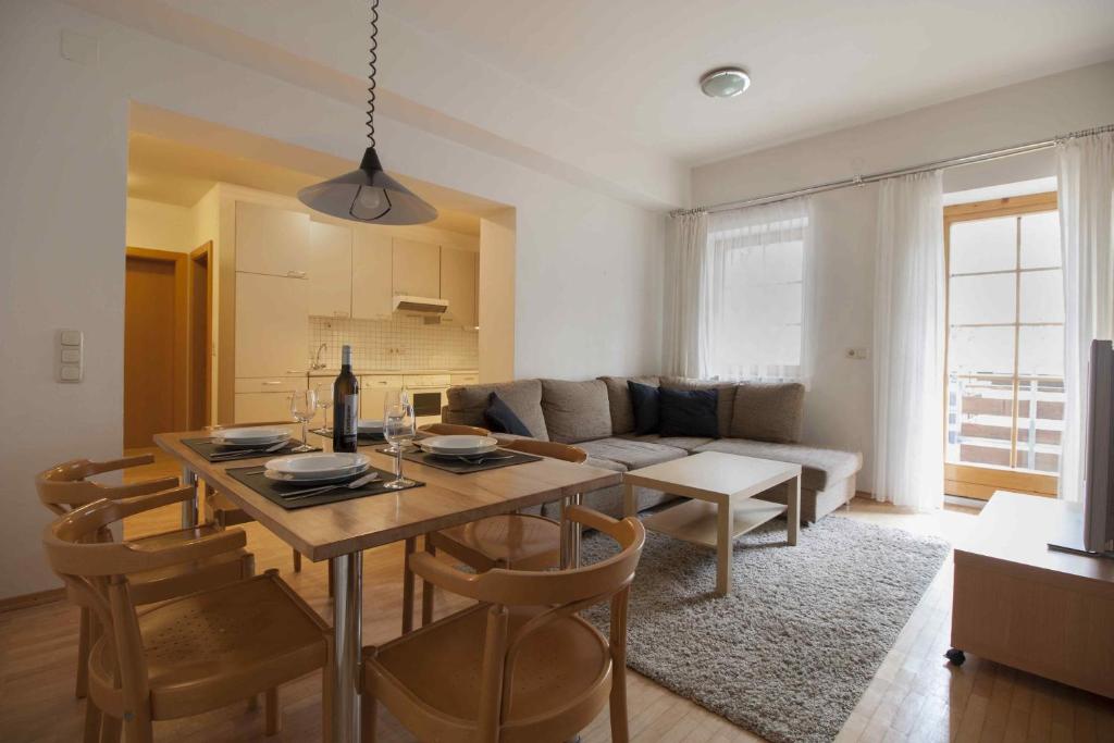 a living room with a table and a couch at Appartements Christophorus in Bad Hofgastein