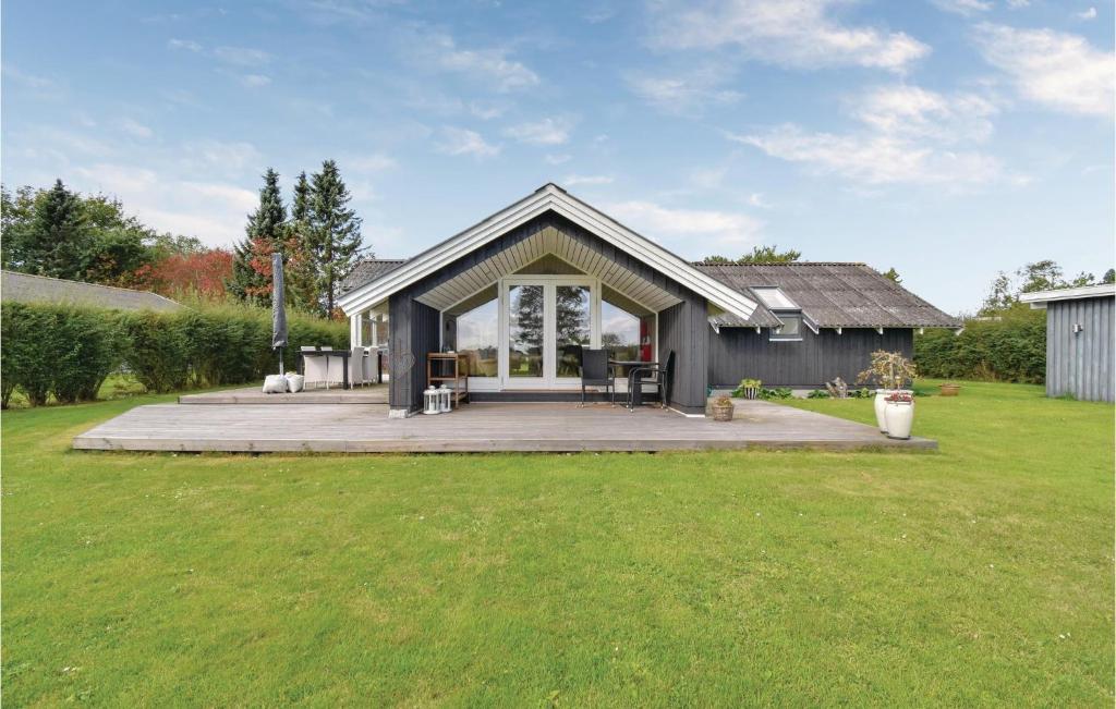 a house with a large backyard with green grass at Three-Bedroom Holiday Home In Otterup in Otterup