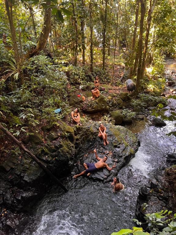 a group of people sitting on rocks in a river at Utria hostel in El Valle