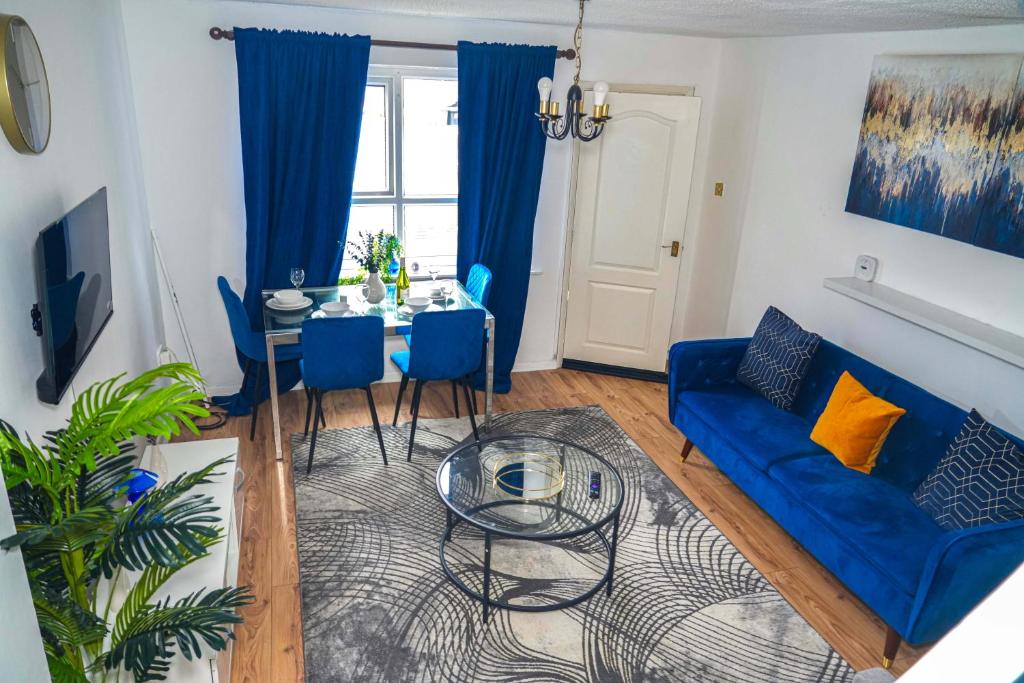 LoughtonにあるLuxury Home Away from Homeの青いソファとテーブルのあるリビングルーム