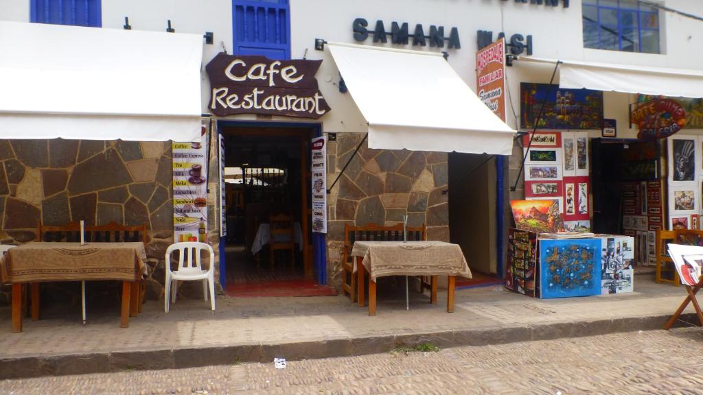 a cafe restaurant with tables and chairs in front of it at Hospedaje Samana Wasi Pisac in Pisac