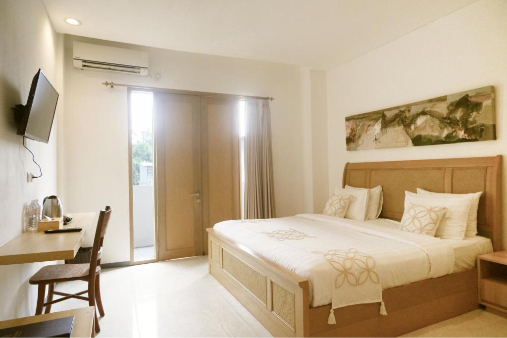 ウブドにあるME Rooms Ubud by ME Villasのベッドとテーブルと机のある寝室