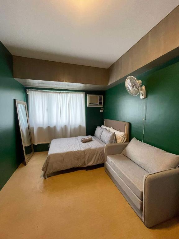 a room with two beds and a couch in it at Avida Towers Davao City by darpm in Davao City