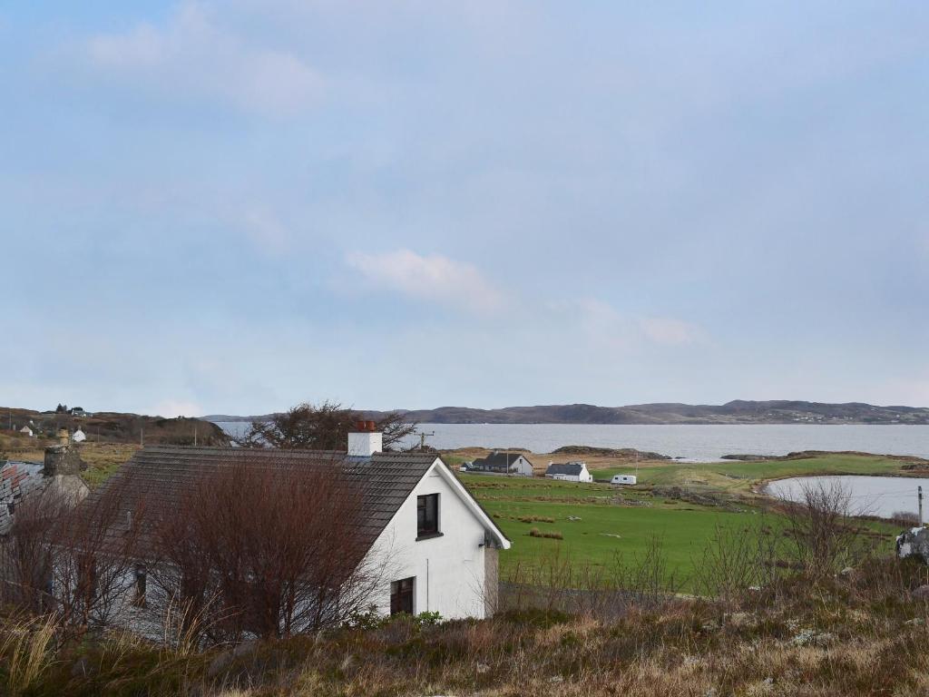 a white house sitting on top of a hill next to a lake at Cuckoos Nest in Cove