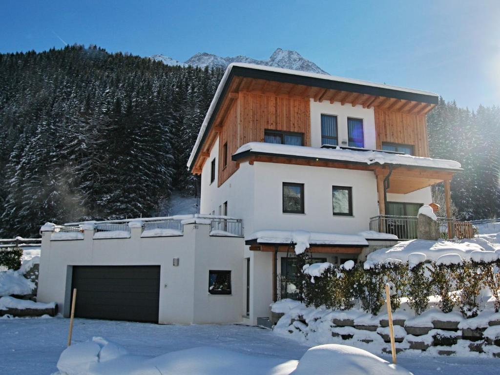 a house with a garage in the snow at Apart Mirjam in Pettneu am Arlberg