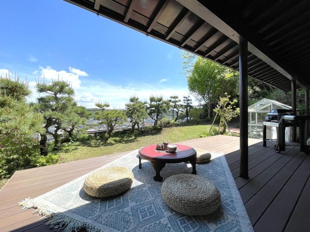 a patio with a table and chairs on a deck at 【 円 madoka 】逗子鎌倉で暮らすように過ごす一棟貸し宿泊施設​ in Zushi