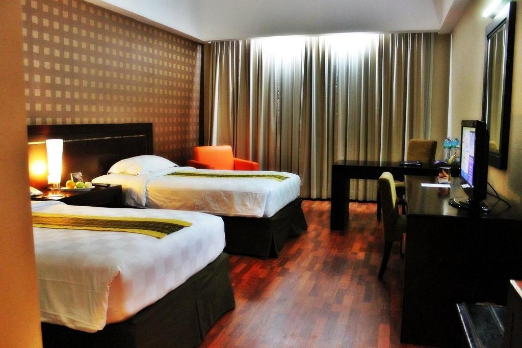Postel nebo postele na pokoji v ubytování Grand Elite Hotel Pekanbaru