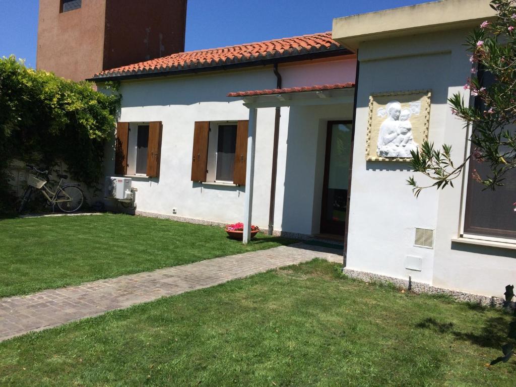 uma casa branca com um jardim e um quintal em Holiday home Bianco Convento em Lido di Venezia