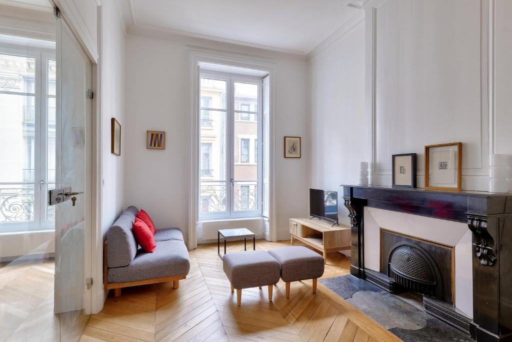 - un salon avec une cheminée et une chaise dans l'établissement Appartement au coeur de la presqu'ile, à Lyon
