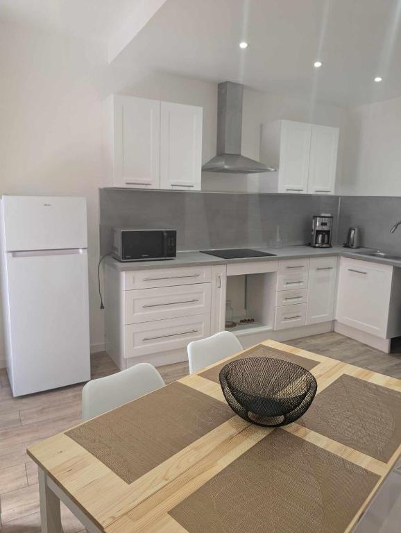 une cuisine avec une table et un réfrigérateur blanc dans l'établissement appartement dans le village, à Néoules