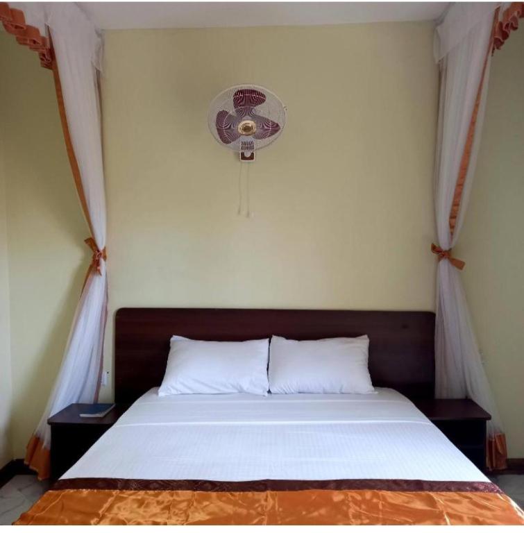 a bedroom with a bed with a fan at Mtwapa june apartment 2 in Mtwapa