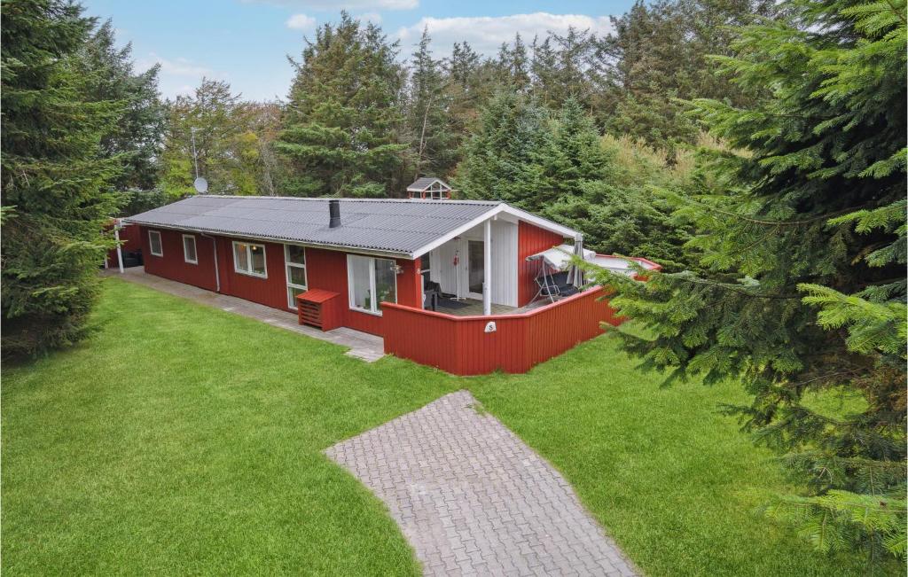 a red house in the middle of a yard at Holiday Home Agertoften Løkken V in Løkken