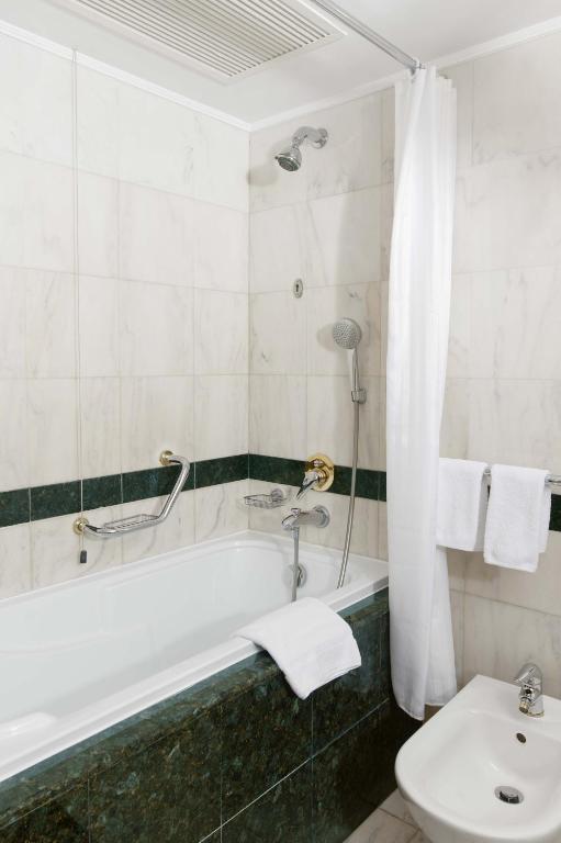 a bathroom with a bath tub and a toilet at Grand Hotel Bucharest in Bucharest