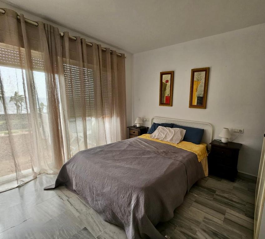 sypialnia z łóżkiem i dużym oknem w obiekcie Casa de Dolores w mieście Estepona