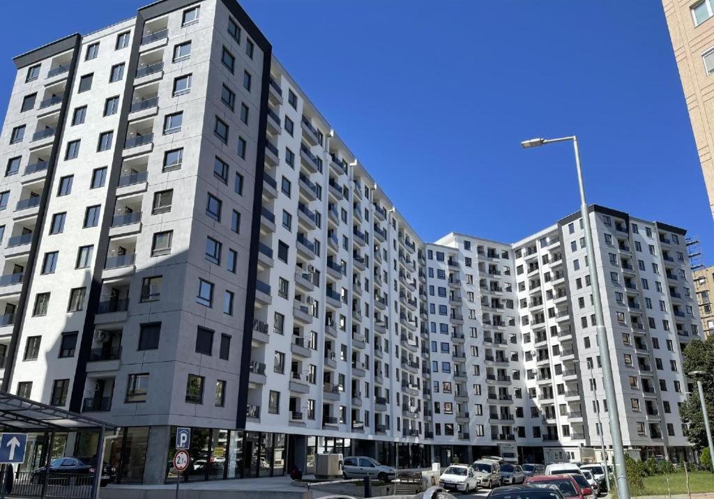 a large white apartment building on a city street at Luxury Apartment in Aerodrom in Skopje