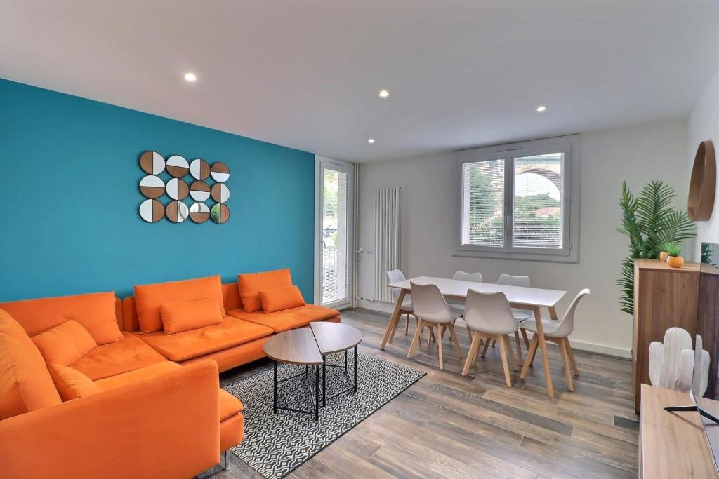 un salon avec un canapé orange et une table dans l'établissement The Aixoise Escape - Close to the city center, à Aix-en-Provence