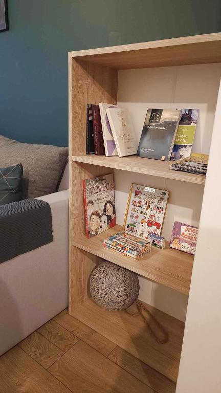 półka z książkami i czasopismami w obiekcie Okno na Śnieżkę, Apartament z 2 Łazienkami, tarasem, ogrodem, parkingiem i pięknym widokiem w mieście Karpacz
