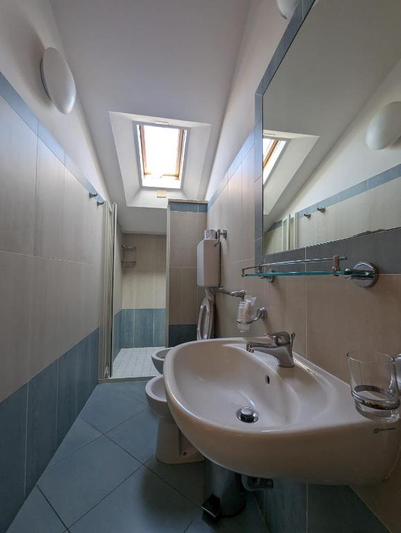łazienka z umywalką, prysznicem i lustrem w obiekcie Hotel Doria w mieście Bellaria-Igea Marina