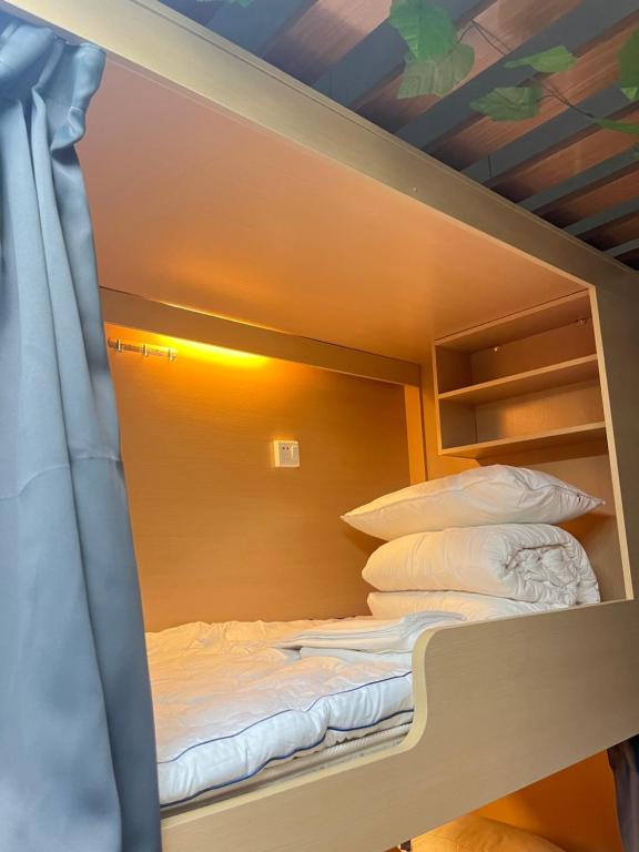 Postel nebo postele na pokoji v ubytování Zhihexing Youth Hostel-知和行青年酒店