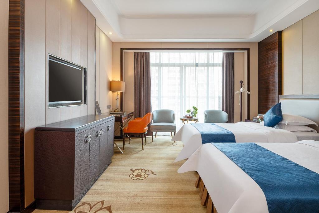 Postel nebo postele na pokoji v ubytování Dongguan Kai Benli International Hotel