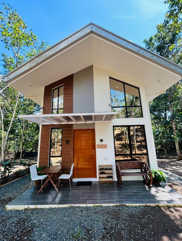 a small house with a large front porch at Tagaytay's Cozy Loft-type Forest House and Camp in Silang