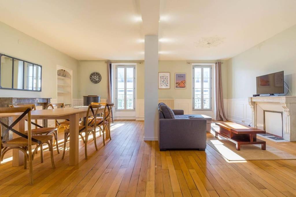 - un salon avec une table à manger et une cheminée dans l'établissement Le Devosge, à Dijon